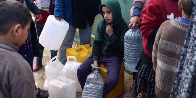 A child looks on as Palestinians wait to collect drinking water amid shortages, at a tent camp sheltering people who fled their houses due to Israeli strikes, in Rafah in the southern Gaza Strip January 28, 2024. REUTERS/Saleh Salem